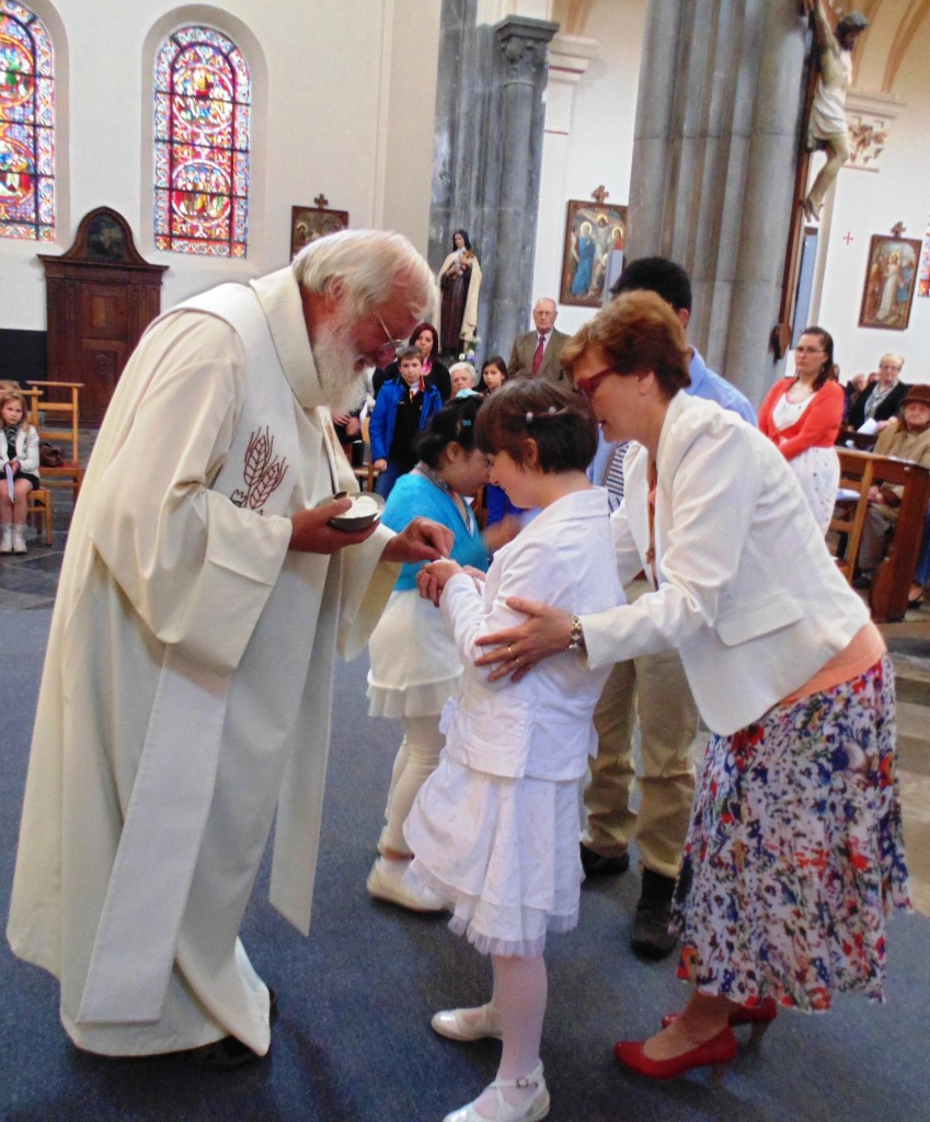 Une enfant reçoit la communion pour la première fois.
